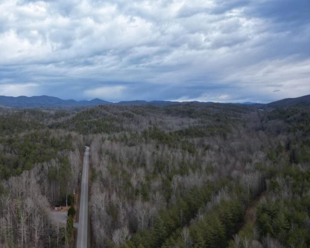 Aerial drone photo of a road cutting through forested mountain ridges